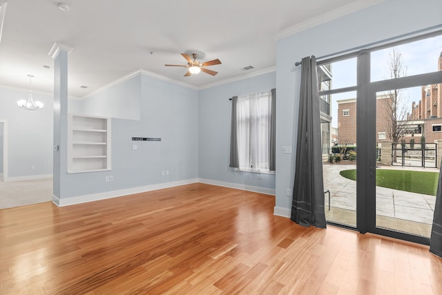 unfurnished room with ceiling fan with notable chandelier, light wood-type flooring, built in shelves, and crown molding