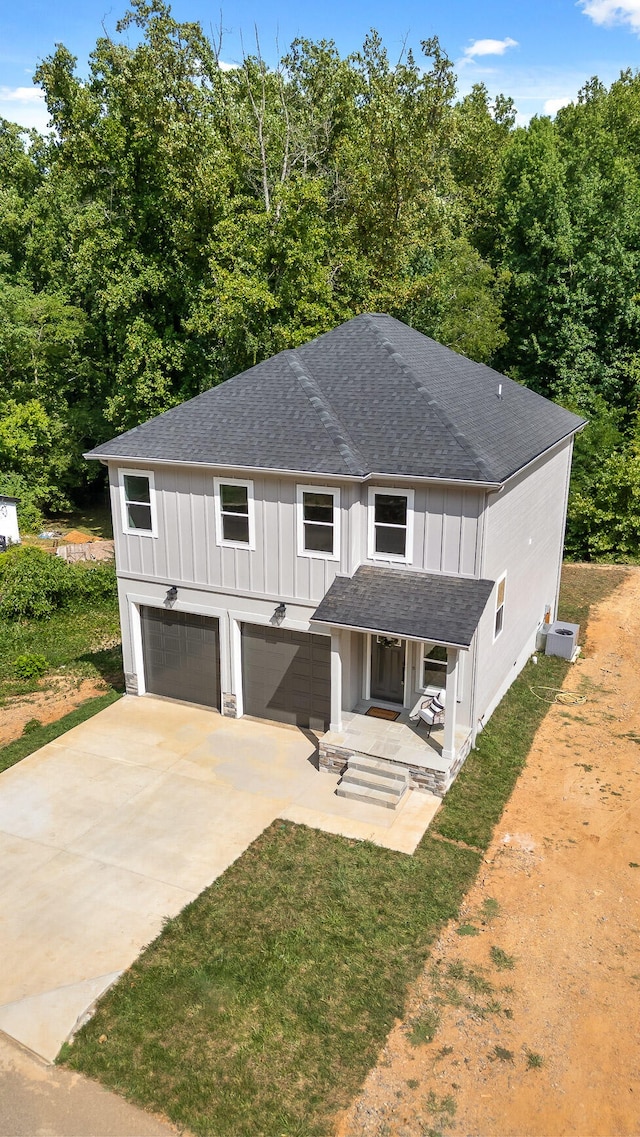 modern farmhouse style home featuring central AC, a front yard, and a garage