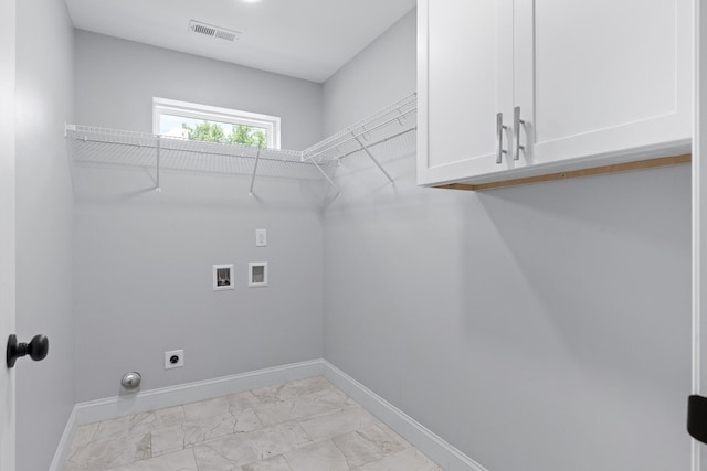 clothes washing area with cabinets, hookup for an electric dryer, and hookup for a washing machine