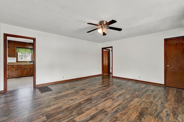 empty room with ceiling fan, a textured ceiling, and dark hardwood / wood-style flooring