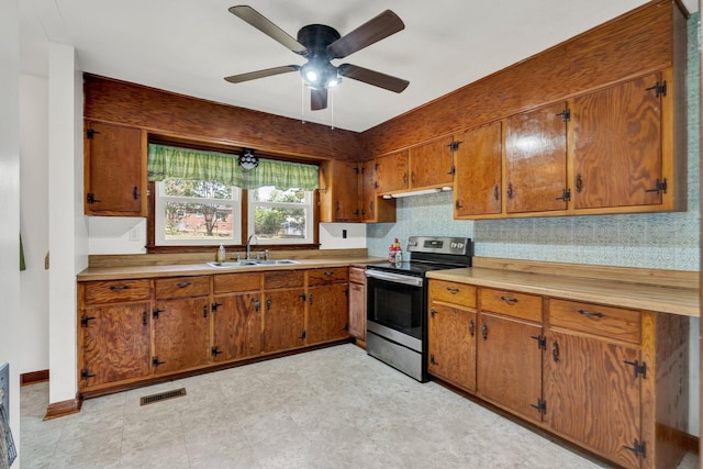 kitchen with stainless steel range with electric cooktop, backsplash, ceiling fan, and sink