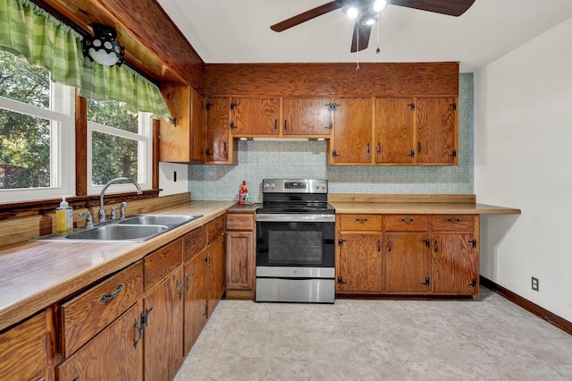 kitchen with decorative backsplash, stainless steel range with electric stovetop, sink, and ceiling fan