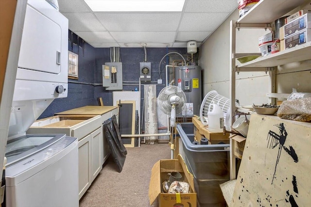 kitchen featuring electric panel, white cabinetry, stacked washing maching and dryer, a drop ceiling, and water heater