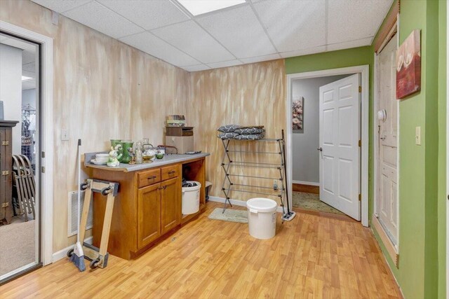 bathroom with wood walls, vanity, a paneled ceiling, and hardwood / wood-style floors