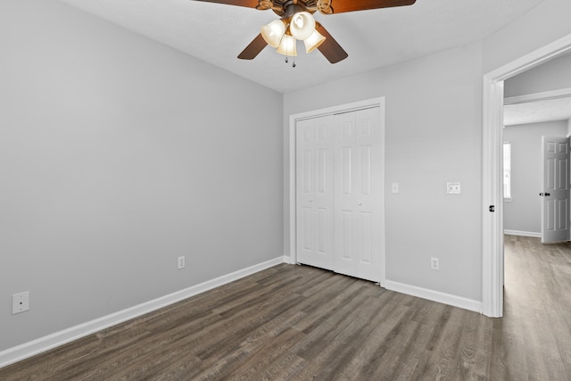 unfurnished bedroom featuring a textured ceiling, dark hardwood / wood-style floors, ceiling fan, and a closet