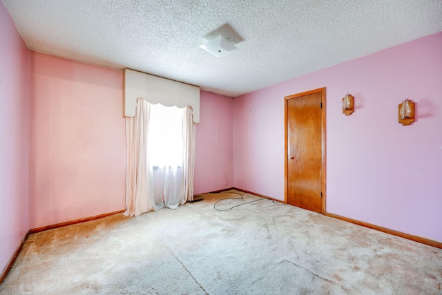 carpeted empty room featuring a textured ceiling