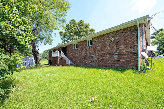 4803 Cordelia Ln, Chattanooga, TN 37416 - rear view of property featuring a yard, brick siding, and a storage shed