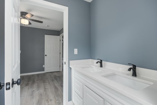 bathroom with wood-type flooring, vanity, and ceiling fan