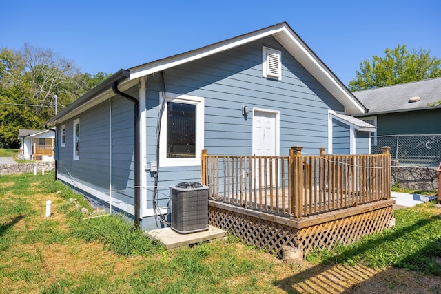 rear view of property with central AC, a yard, and a wooden deck