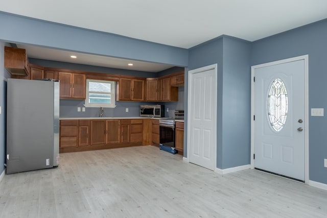 kitchen featuring light hardwood / wood-style floors, appliances with stainless steel finishes, and sink