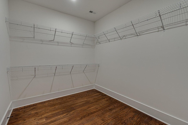 spacious closet with dark hardwood / wood-style flooring