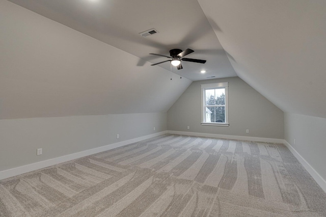 additional living space with ceiling fan, light colored carpet, and vaulted ceiling