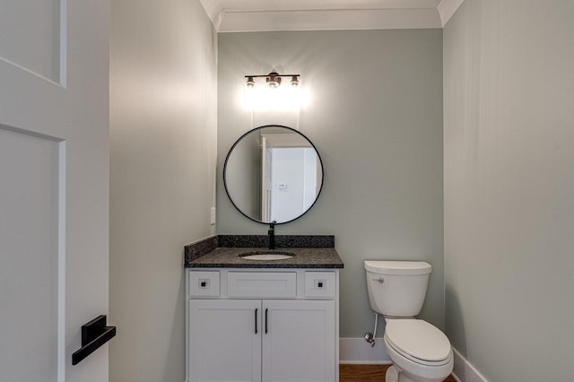 bathroom featuring toilet, vanity, and ornamental molding