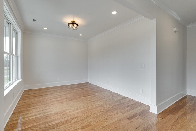 empty room with light hardwood / wood-style floors and crown molding