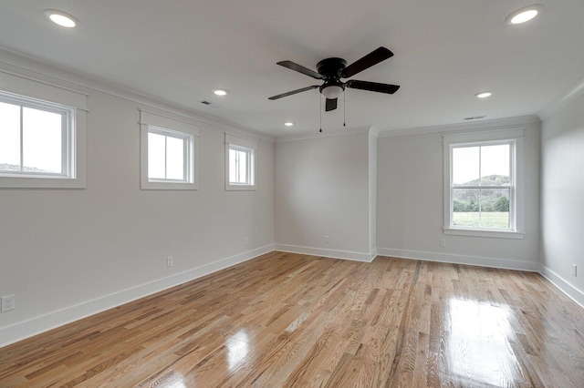 spare room with ceiling fan, plenty of natural light, light wood-type flooring, and ornamental molding