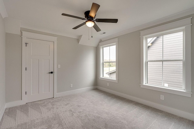 empty room with light colored carpet, ceiling fan, and crown molding