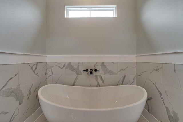 bathroom featuring tile walls and a tub