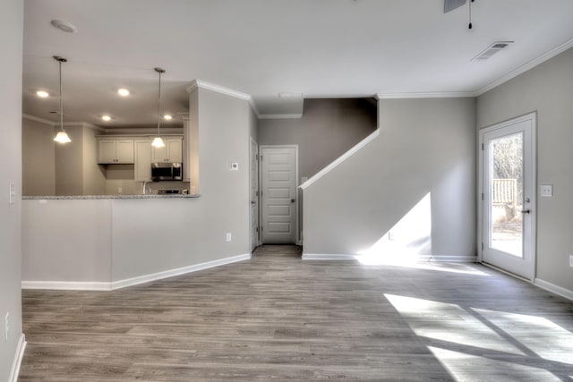 unfurnished living room featuring ornamental molding and hardwood / wood-style flooring