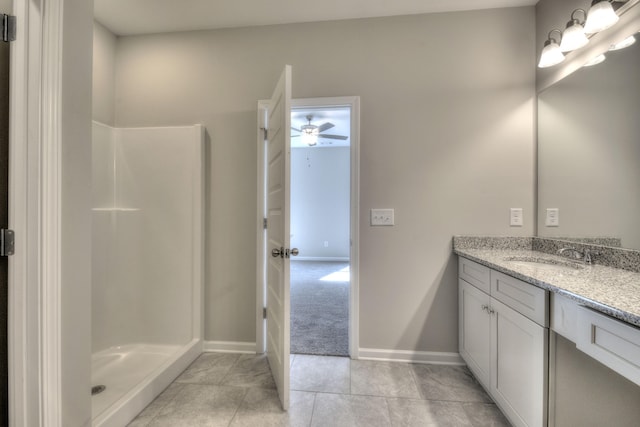 bathroom with tile patterned flooring, walk in shower, and vanity