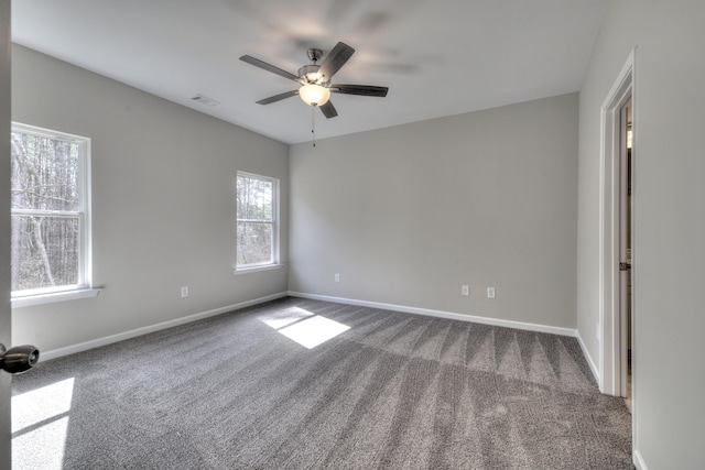 carpeted empty room featuring a healthy amount of sunlight and ceiling fan