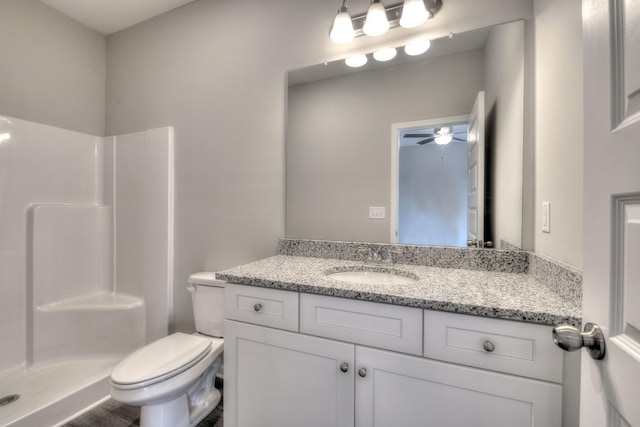 bathroom featuring walk in shower, vanity, toilet, and ceiling fan