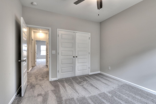 unfurnished bedroom featuring ceiling fan, light colored carpet, and a closet