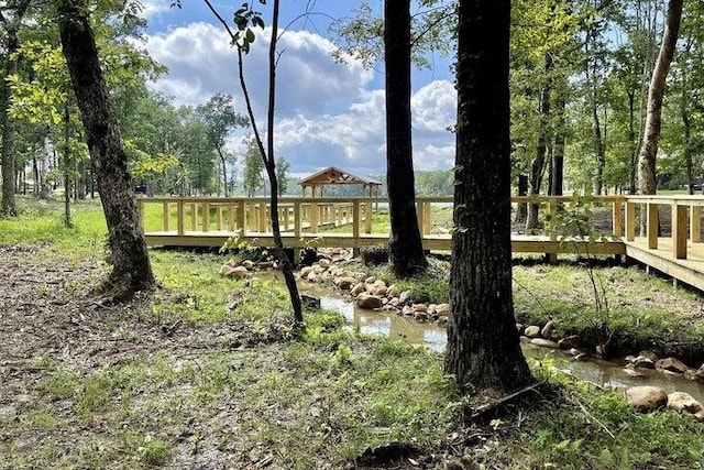 view of yard with a deck with water view