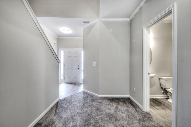 corridor with ornamental molding and hardwood / wood-style floors