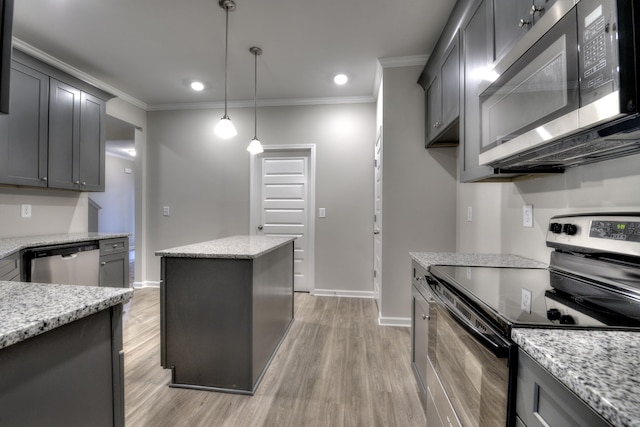 kitchen featuring light wood-type flooring, hanging light fixtures, stainless steel appliances, and light stone counters