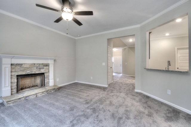 unfurnished living room featuring carpet floors, a stone fireplace, ornamental molding, and ceiling fan