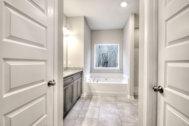 bathroom with vanity, a washtub, and tile patterned floors