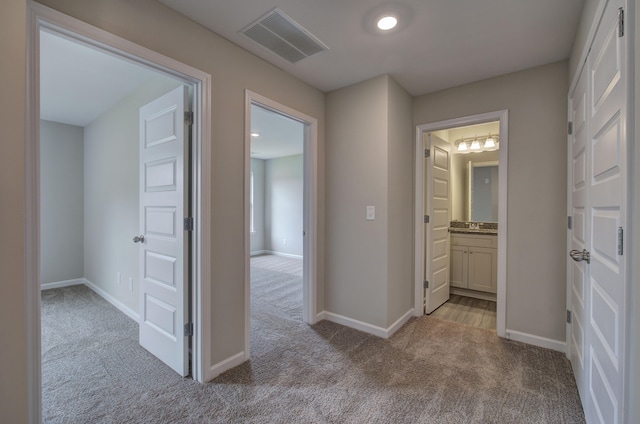 hallway featuring light colored carpet