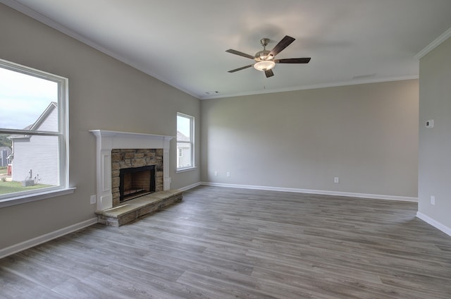 unfurnished living room with ceiling fan, a fireplace, crown molding, and hardwood / wood-style floors