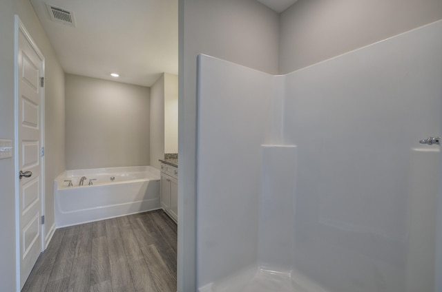 bathroom with vanity, hardwood / wood-style floors, and a bathing tub