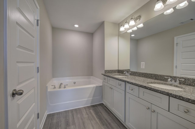 bathroom featuring a tub to relax in, vanity, and hardwood / wood-style flooring