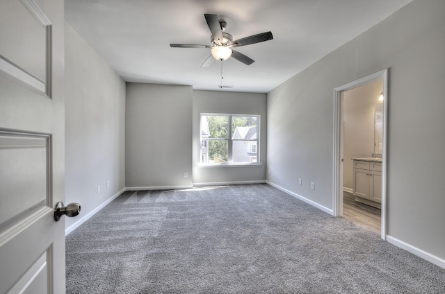 unfurnished bedroom featuring ceiling fan, ensuite bathroom, and carpet