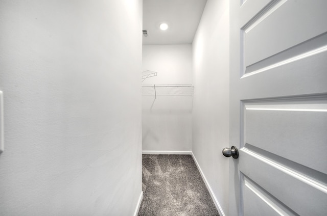 spacious closet featuring dark colored carpet