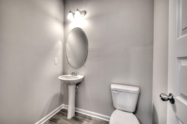 bathroom featuring wood-type flooring and toilet