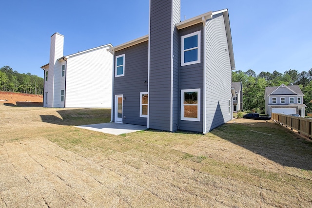 rear view of property featuring a yard and a patio area