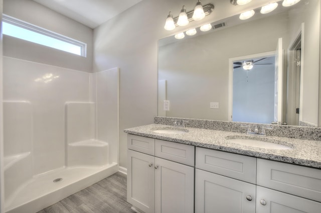 bathroom featuring hardwood / wood-style floors, ceiling fan, a shower, and vanity