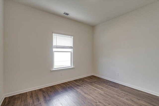 empty room with dark hardwood / wood-style flooring