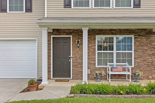 doorway to property featuring a porch and a garage