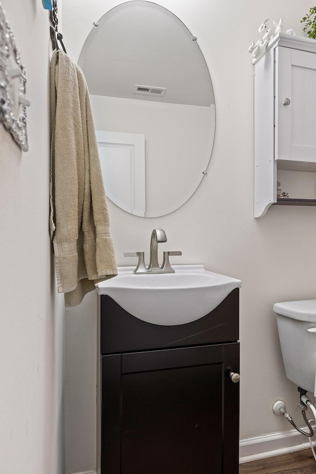 bathroom featuring vanity, toilet, and hardwood / wood-style flooring