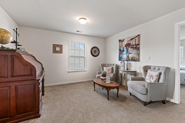 living area with light carpet and a textured ceiling