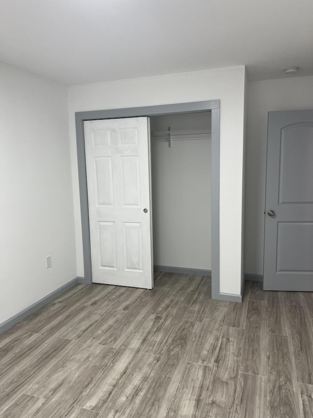 unfurnished bedroom with a closet and hardwood / wood-style floors