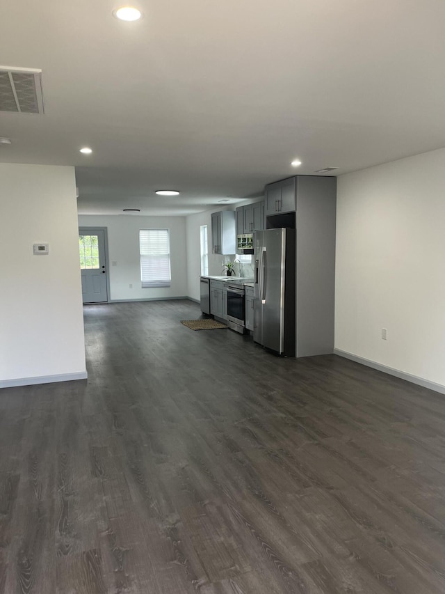 unfurnished living room with dark hardwood / wood-style flooring and sink