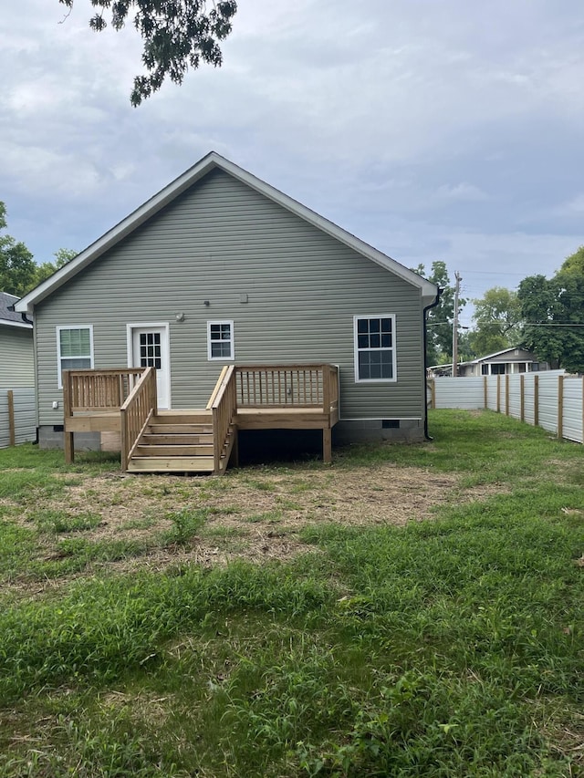 back of house with a lawn and a deck