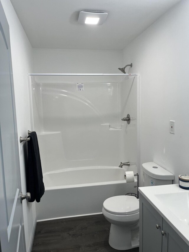 full bathroom featuring hardwood / wood-style floors, shower / bathtub combination, vanity, and toilet