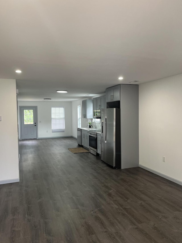 unfurnished living room with sink and dark hardwood / wood-style flooring