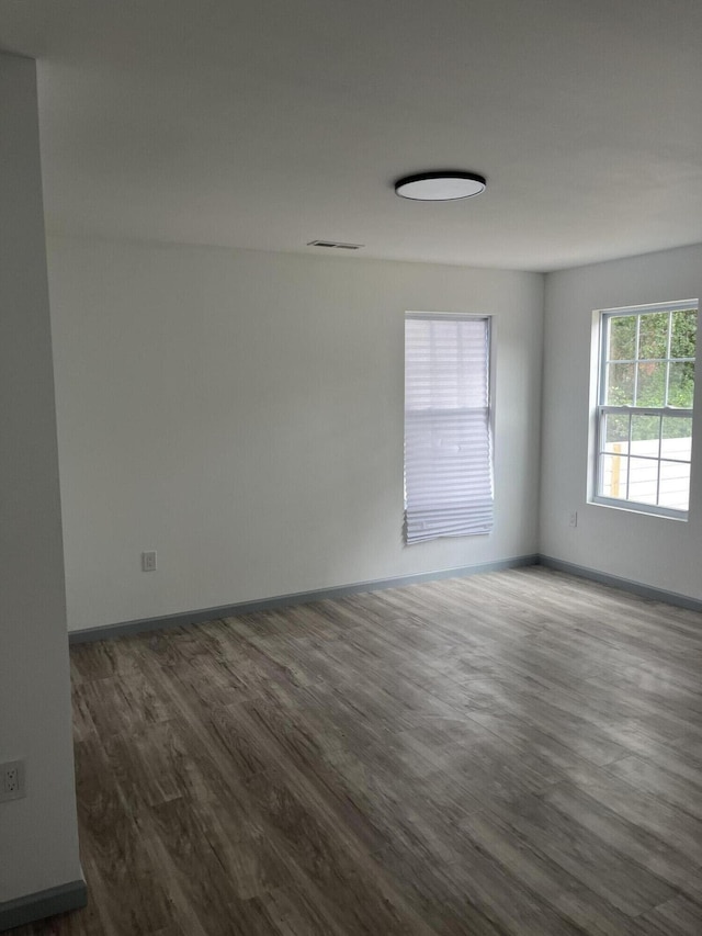 unfurnished room with dark hardwood / wood-style flooring